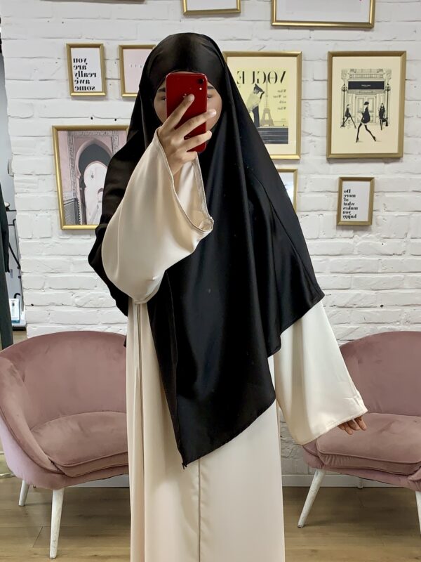 Photographie de la modèle portant le produit Khimar Satin de couleur noir de la boutique EL JAWARIYA